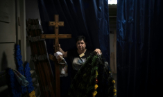 Svitlana Ostapenko, gérante du funérarium de Sumy, dans le nord-est de l'Ukraine, prépare, le 11 juin 2025, une croix et un couronne mortuaire pour l'enterrement d'un jeune soldat tué récemment lors de combats contre les forces russes ( AFP / Florent VERGNES )