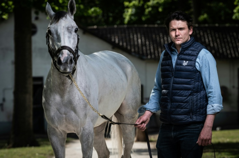 L'entraineur David Cottin et le cheval "Le Berry" à Lamorlaye, le 10 mai 2021 dans l'Oise ( AFP / Martin BUREAU )