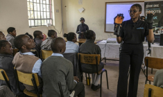 Norah Kimathi (D), ingénieure kényane en robotique et cofondatrice de l'entreprise ZeroBionic montre, le 4 septembre 2026, un bras robotisé capable de traduire des paroles en signes à des élèves d'une école pour enfants sourds à Nairobi ( AFP / SIMON MAINA )