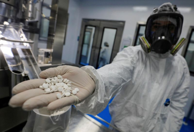 Un technicien de laboratoire tient des comprimés