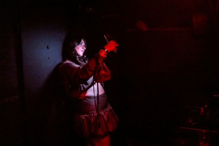 Une cliente utilise son téléphone pour prendre un selfie dans un club souterrain servant d'abri anti-bombes à Tel Aviv, le 9 mars 2026 ( AFP / OLYMPIA DE MAISMONT )