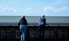 Des visiteurs à côté de plaques portant les noms de pêcheurs disparus en mer à Urk, le 3 juillet 2025 aux Pays-Bas ( AFP / Nicolas TUCAT )