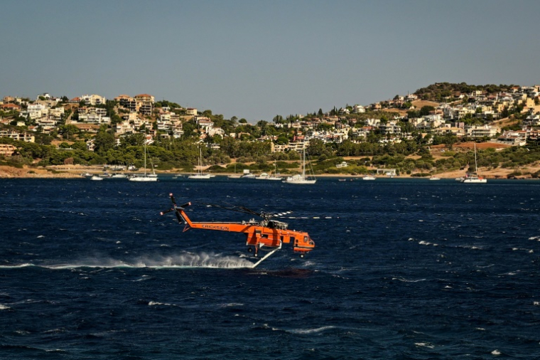 Un hélicoptère de lutte contre les incendies Erickson se remplit d'eau dans la mer lors d'un incendie de forêt à Palaia Fokaia, à environ 43 km au sud d'Athènes, le 9 août 2025. ( AFP / Aris MESSINIS )