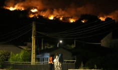 Des habitants observent les flammes sur les crêtes des collines tandis que les pompiers luttent contre un incendie de forêt dans la région de Cebreros, près d’Ávila, à 80 km à l’ouest de Madrid, dans la nuit du 24 juillet 2026 ( AFP / Cesar MANSO )