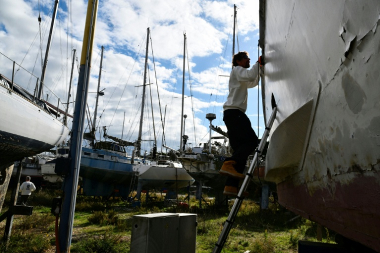 Guillaume Delaunay cherche des pièces réutilisables ou recyclables, le 7 novembre 2025 dans un cimetière de bateaux à Port-Saint-Louis-du-Rhône, dans les Bouches-du-Rhône ( AFP / Christophe SIMON )