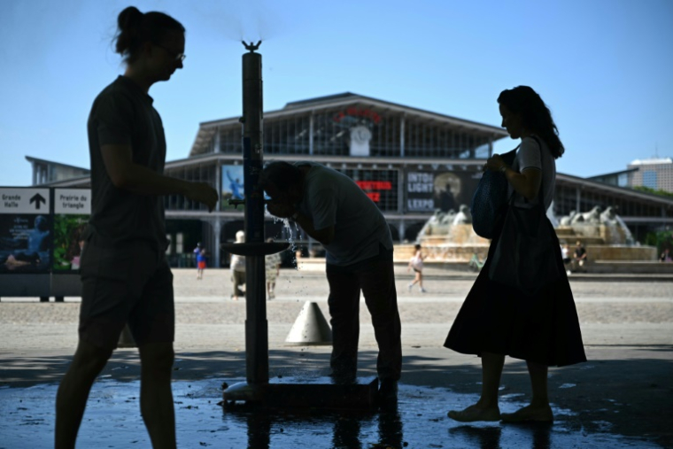 Des personnes se rafraîchissent à une fontaine publique près de la Grande Halle de La Villette alors qu'une vague de chaleur frappe le sud de l'Europe, à Paris, le 29 juin 2025 ( AFP / Julie SEBADELHA )