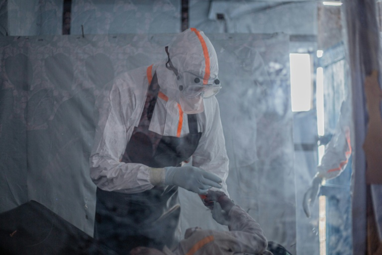 Un médecin administre un sérum à un patient atteint de la maladie à virus Ebola au centre de traitement Ebola (CTE) de Rwampara, le 13 juillet 2026 à Bunia, dans la province de l'Ituri, en RDC ( AFP / BENEDICTION MURHABAZI )