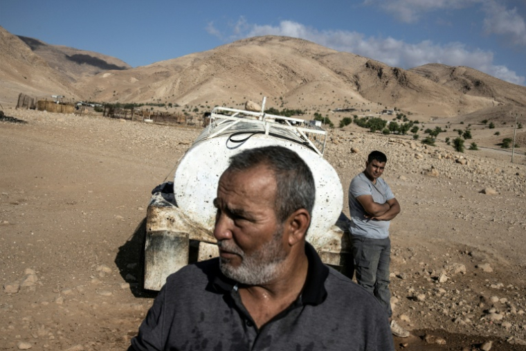 Un bédouin palestinien et son fils à proximité d'une citerne à Ras Ein al-Auja, dans la vallée du Jourdain, en Cisjordanie occupée, le 30 septembre 2025 ( AFP / JOHN WESSELS )