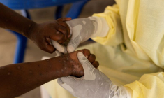 Une infirmière prélève un échantillon sur un enfant déclaré suspect de Mpox au centre de traitement de Munigi