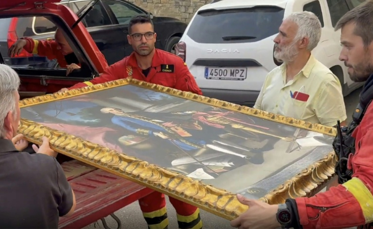Image tirée d'une vidéo diffusée par l'Unité militaire d'urgence (UME) espagnole montrant des pompiers évacuant un tableau alors qu'un incendie de forêt menace le monastère de San Juan de la Peña, dans la province d'Aragon, le 13 août 2026 dans le sud-ouest de l'Espagne ( UME / Handout )