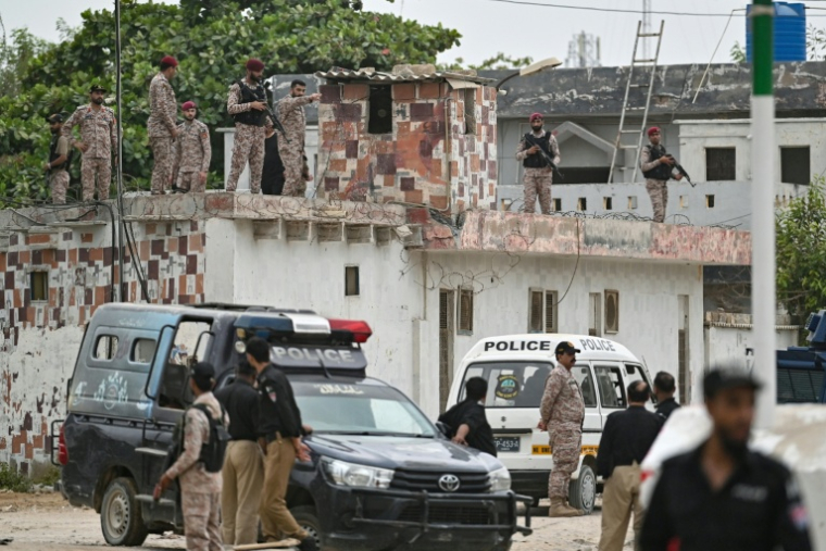 Des membres des forces de sécurité inspectent le toit d'un complexe pendant une opération de sécurisation, après une explosion et une attaque à Karachi, le 28 juin 2026 au Pakistan ( AFP / Asif HASSAN )