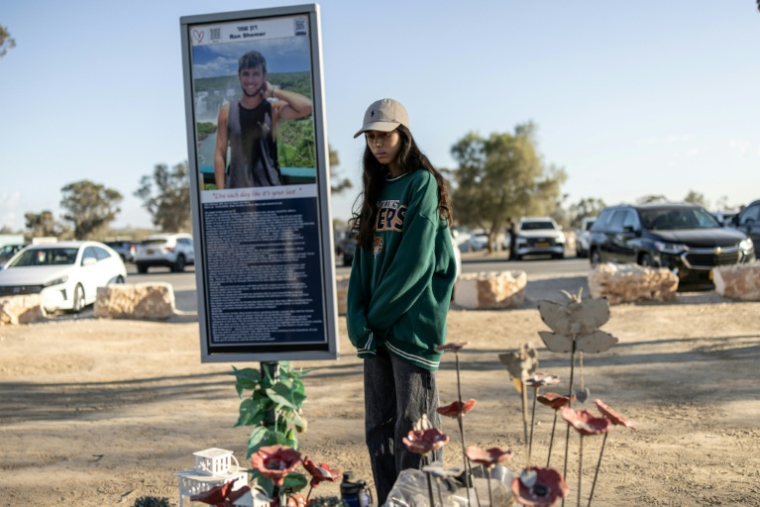 Une femme se recueille le 7 octobre 2025 devant le mémorial d'une victime de l'attaque du Hamas au festival Nova deux ans plus tôt, à Réïm, dans le sud d'Israël ( AFP / JOHN WESSELS )