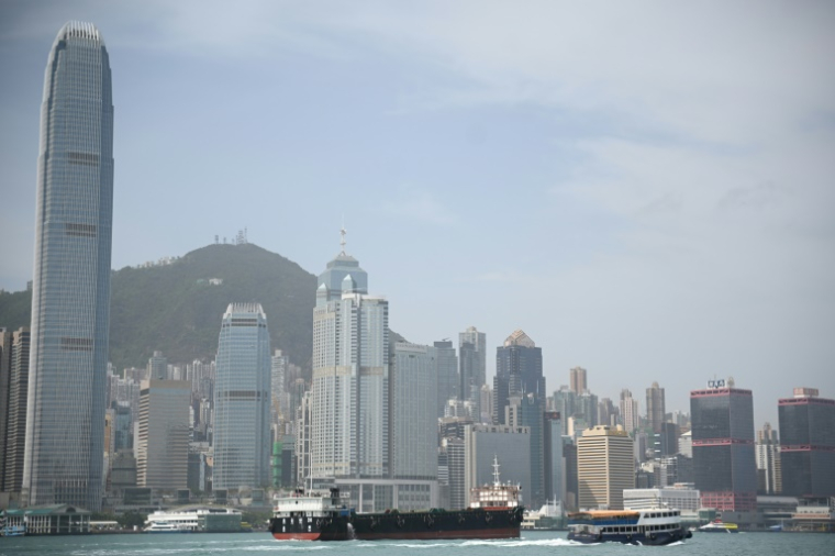 Une barge porte-conteneurs à vide traverse le port de Victoria à Hong Kong, le 16 avril 2025 ( AFP / Peter PARKS )