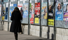 Une femme passe devant un panneau électoral avec les candidats à la mairie de Paris, le 9 mars 2026, à Paris ( AFP / Ludovic MARIN )