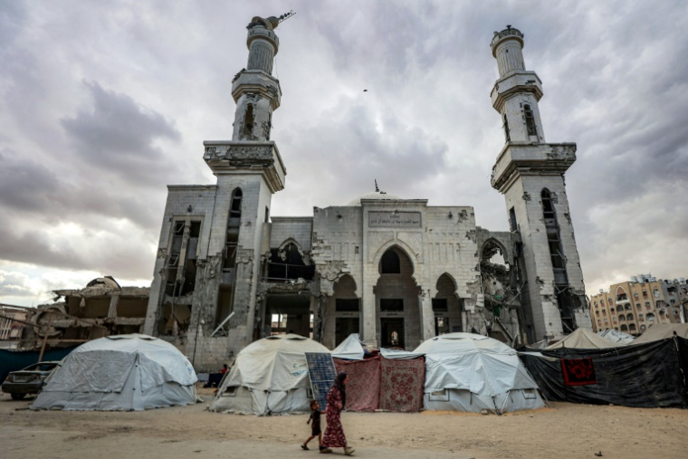 Des tentes de déplacés palestiniens installées devant une mosquée fortement endommagée à Khan Younès, dans le sud de la bande de Gaza, le 6 octobre 2025 ( AFP / Omar AL-QATTAA )
