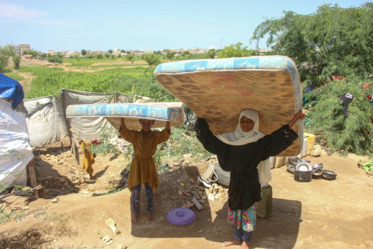 Une famille de déplacés au Yémen porte des matelas après avoir dû fuir sa maison en raison des combats entre les Houthis et les forces gouvernementales à Hajjah, le 7 octobre 2026 ( AFP / Essa AHMED )
