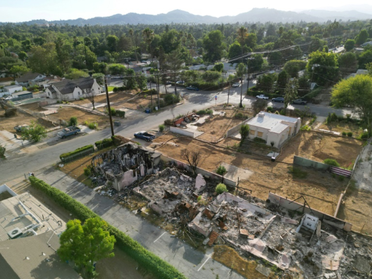 Vue aérienne de terrains résidentiels dégagés après la destruction de maisons lors de l'incendie d'Eaton en janvier 2025, à côté de maisons encore debout, parmi lesquelles la maison de Karen Girard, le 20 août 2025 à Altadena, en Californie ( AFP / Robyn Beck )