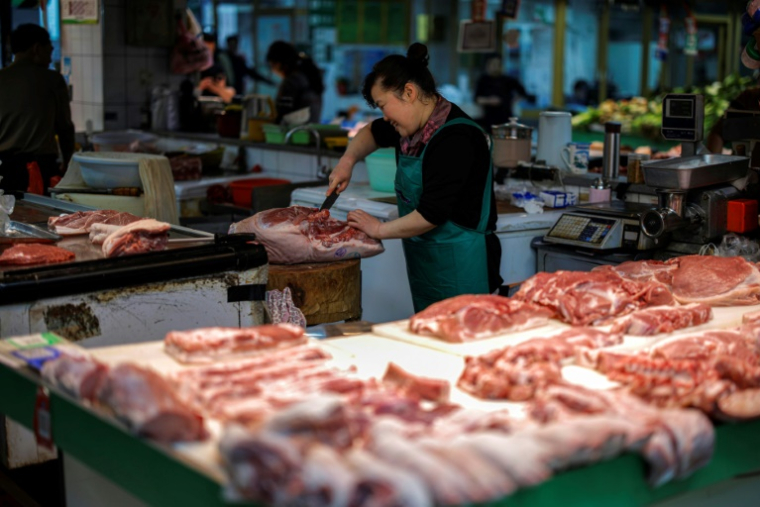 Une vendeuse coupe du porc sur un marché de Hangzhou, dans la province du Zhejiang, dans l'est de la Chine, le 10 avril 2025 ( AFP / - )