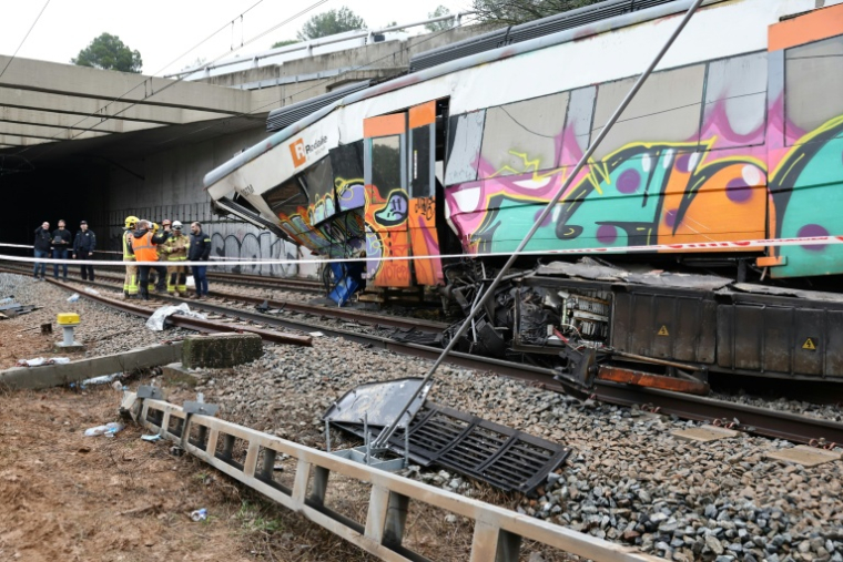 Des enquêteurs et des pompiers sur le site où un train de banlieue a percuté un mur de soutènement tombé sur les voies, le 21 janvier 2026 entre Sant Sadurni d'Anoia et Gelida, près de Barcelone, en Catalogne ( AFP / Josep LAGO )