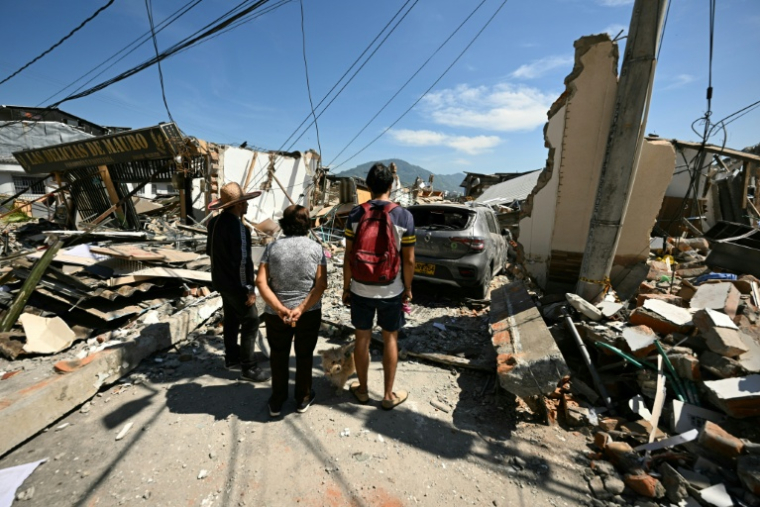 Des voisins observent un bâtiment effondré après le séisme à Pereira, en Colombie, le 11 août 2026 ( AFP / Luis ACOSTA )