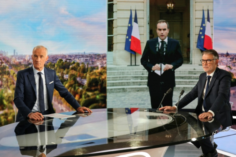 Olivier Faure (D) premier secrétaire du Parti Socialiste et le journaliste Gilles Bouleau, devant une image du Premier ministre démissionnaire Sébastien Lecornu, au 20h de TF1, à Boulogne-Billancourt, le 6 octobre 2025 ( AFP / Ludovic MARIN )