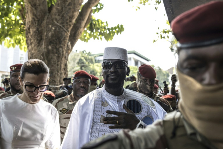 Le président guinéen et candidat à la présidence Mamadi Doumbouya (centre droit) et son épouse Lauriane Doumbouya (centre gauche) arrivent pour voter dans un bureau de vote à Conakry le 28 décembre 2025, lors de l'élection présidentielle guinéenne ( AFP / PATRICK MEINHARDT )