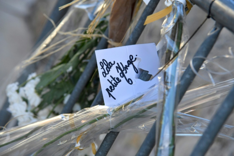 Des fleurs et des cartes déposées devant l'église avant les funérailles de Lola, le 24 octobre 2022, à Paris ( AFP / FRANCOIS LO PRESTI )