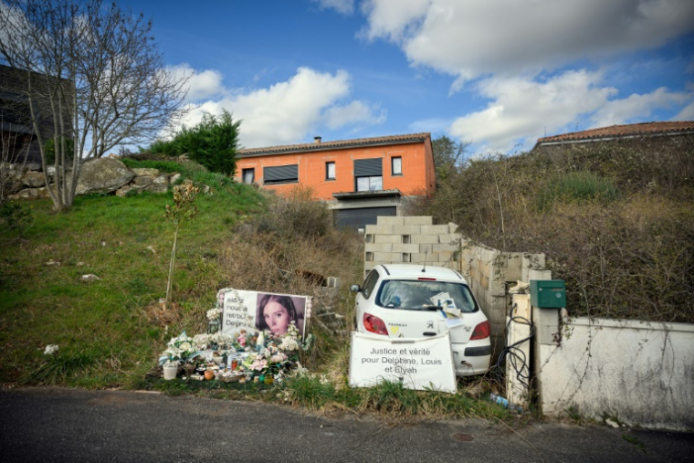 Un portrait de Delphine Jubillar, et des fleurs et bougies déposées devant sa maison à Cagnac-les-Mines, dans le Tarn, le 6 mars 2025 ( AFP / Lionel BONAVENTURE )