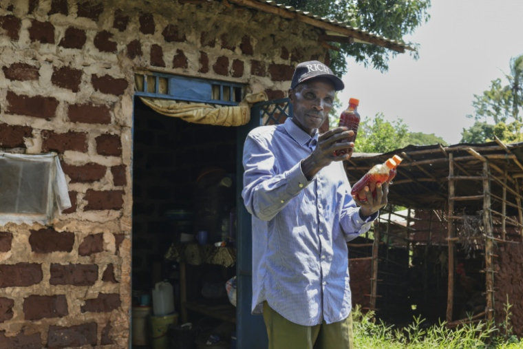 L'apiculteur Stephen Munga montre une partie de sa production de miel issu de la forêt de Mrima hill, à Lunga-Lunga, dans le sud-est du Kenya près de la frontière tanzanienne, le 26 septembre 2025 ( AFP / Tony KARUMBA )