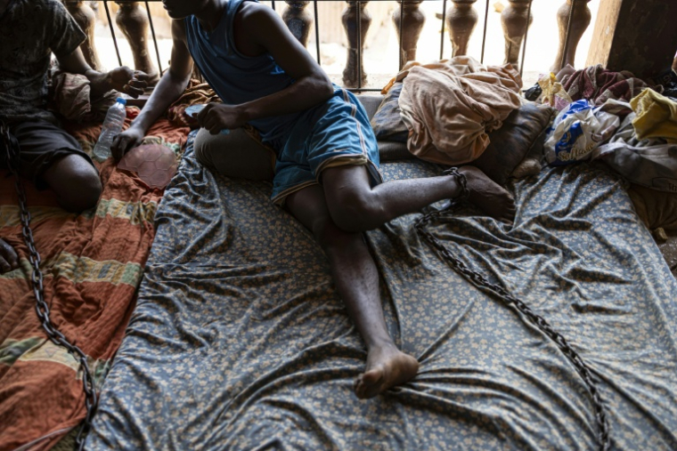 Un toxicomane enchainé pendant son sevrage dans un centre informel de réhabilitation, à la périphérie de Freetown, le 26 avril 2025 en Sierra Leone ( AFP / PATRICK MEINHARDT )