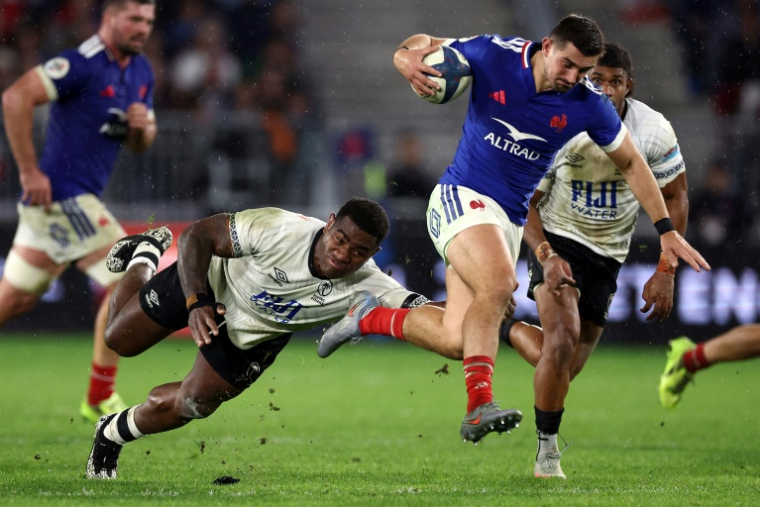 L'arrière du XV de France Thomas Ramos (D) échappe au plaquage du Fidjien Josua Tuisova lors du match international remporté par les Bleus (34-21), le 15 novembre 2025 à Bordeaux ( AFP / ROMAIN PERROCHEAU )