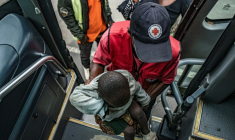 Un membre de la Croix-Rouge rwandaise aide un enfant qui a fui des combats en République démocratique du Congo à monter dans un bus à son arrivée à Bugarama, au Rwanda, le 5 décembre 2025 ( AFP / - )