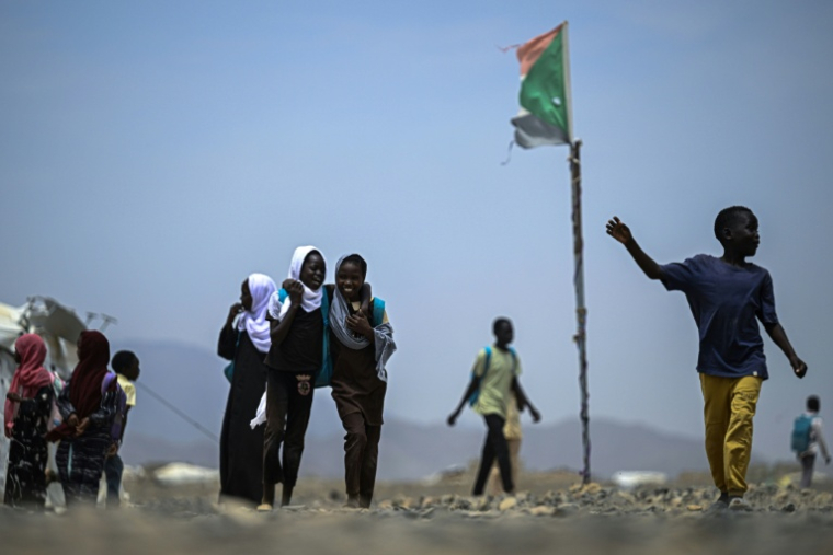 Des élèves sortent de l'école d'un camp de personnes déplacées par la guerre  près de Port-Soudan, le 26 avril 2026 au Soudan ( AFP / Khaled DESOUKI )