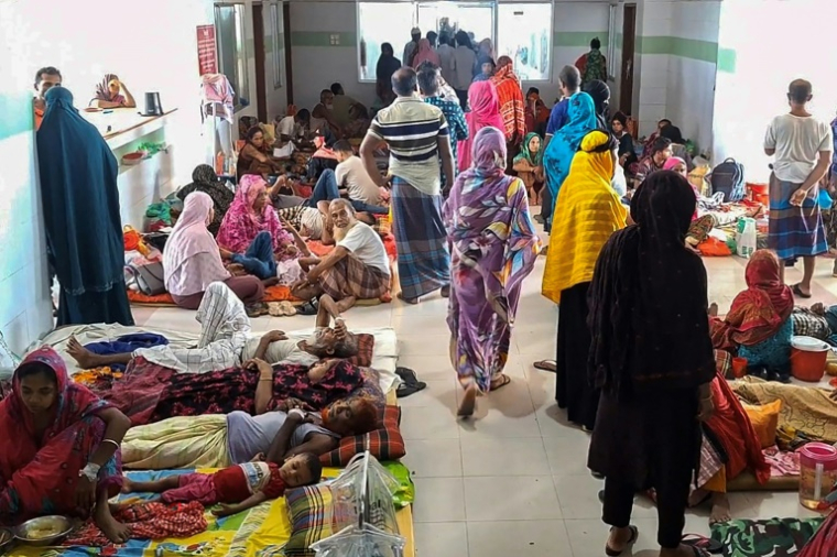 Des patients atteints de la dengue et des membres de leur famille dans un hôpital de Barguna, dans le sud du Bangladesh, le 22 juin 2025 ( AFP / Arifir RAHMAN )