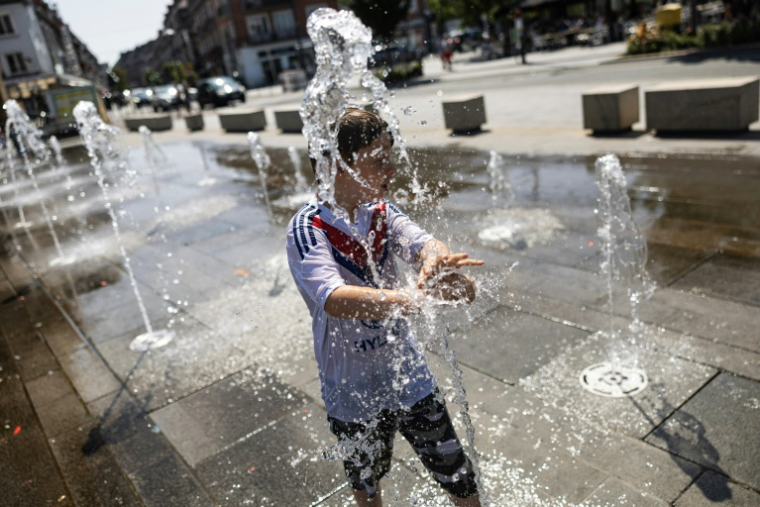 Un enfant se rafraîchit dans une fontaine publique à Calais, dans le nord de la France, le 12 août 2025, alors qu'une vague de chaleur sévit en Europe ( AFP / Sameer Al-DOUMY )