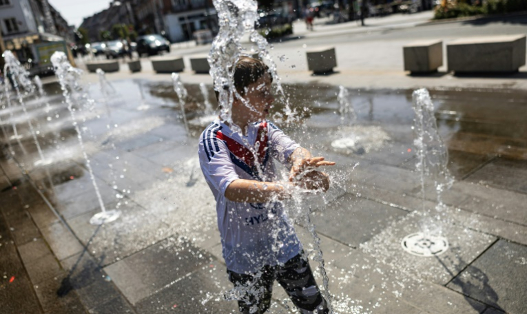 Un enfant se rafraîchit dans une fontaine publique à Calais, dans le nord de la France, le 12 août 2025, alors qu'une vague de chaleur sévit en Europe ( AFP / Sameer Al-DOUMY )