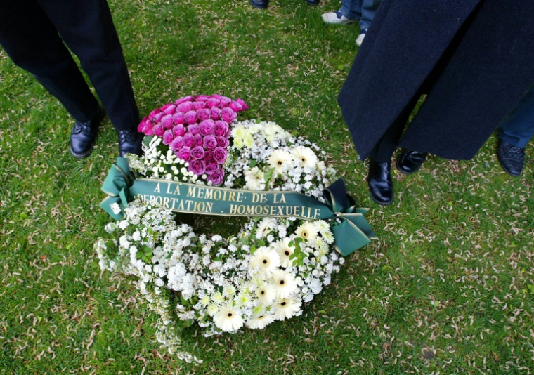 Des membres d'associations homosexuelles déposent une gerbe de leurs avec le triangle rose devant le monument aux morts de Strasbourg, à la mémoire des déportés homosexuels de la Seconde Guerre mondiale, le 28 avril 2002 ( AFP / OLIVIER MORIN )