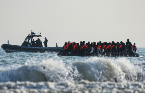 Un bateau de la gendarmerie maritime se tient à proximité d'une embarcation clandestine de migrants tentant de gagner l'Angleterre, le 13 juin 2024 à Gravelines, dans le nord de la France  ( AFP / Sameer Al-DOUMY )