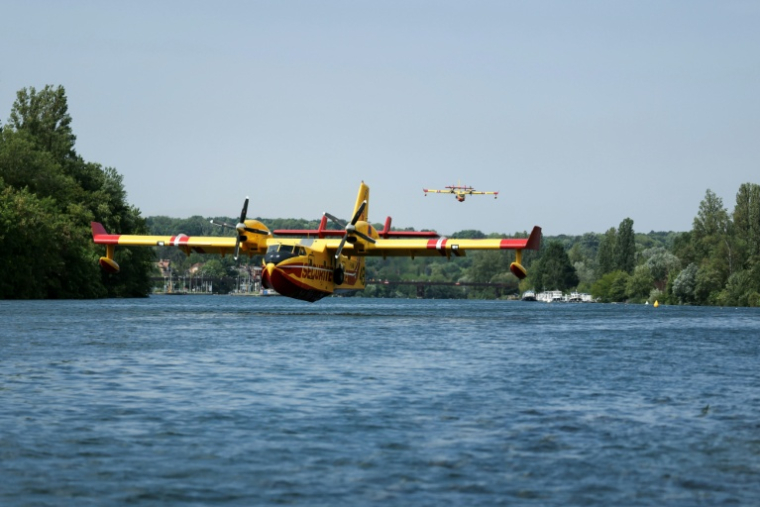 Un Canadair CL-415 de la Sécurité civile effectue des manœuvres d'écopage au-dessus de la Seine à Chartrettes, pour lutter contre un incendie dans la forêt de Fontainebleau, en Ile-de-France ( AFP / Thomas SAMSON )