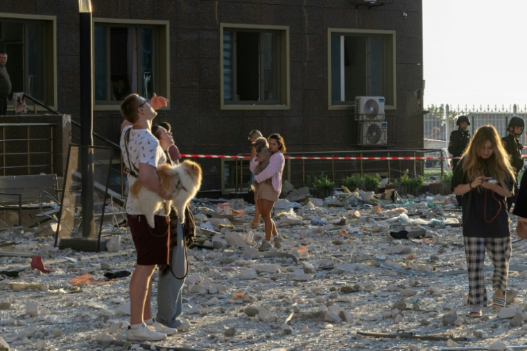 Des habitants se tiennent à l'extérieur d'un immeuble d'habitation endommagé par des frappes de missiles et de drones russes sur la ville portuaire ukrainienne d'Odessa, le 12 septembre 2026   ( AFP / Oleksandr GIMANOV )