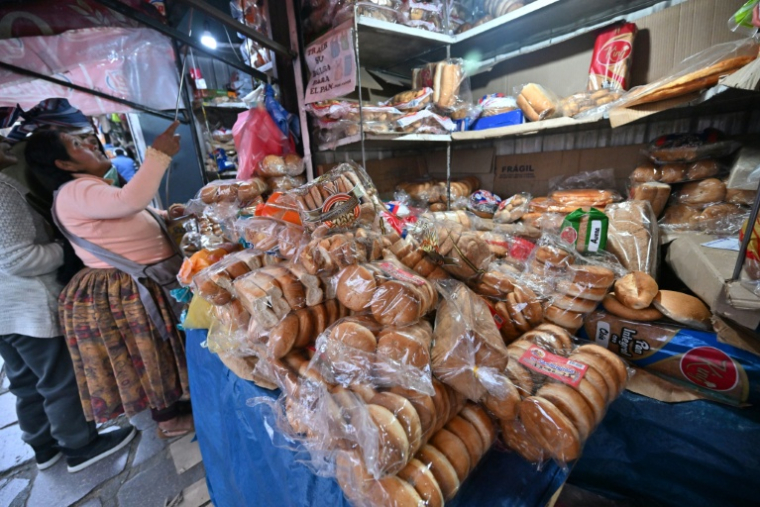 Une femme achète du pain sous sachet sur un marché à La Paz, en Bolivie, le 31 juillet 2025 ( AFP / AIZAR RALDES )