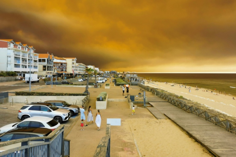 La plage à Lacanau-Océan, où la fumée d'un incendie de forêt s'élève dans le ciel, le 24 juillet 2026 en Gironde ( AFP / Maximilien LAMY )
