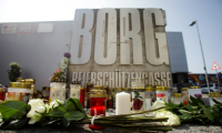 Des fleurs et des bougies déposées devant un établissement scolaire où dix personnes ont été tuées par balles la veille, le 11 juin 2025 à Graz, en Autriche ( AFP / Alex HALADA )