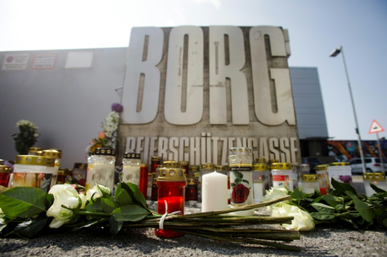 Des fleurs et des bougies déposées devant un établissement scolaire où dix personnes ont été tuées par balles la veille, le 11 juin 2025 à Graz, en Autriche ( AFP / Alex HALADA )