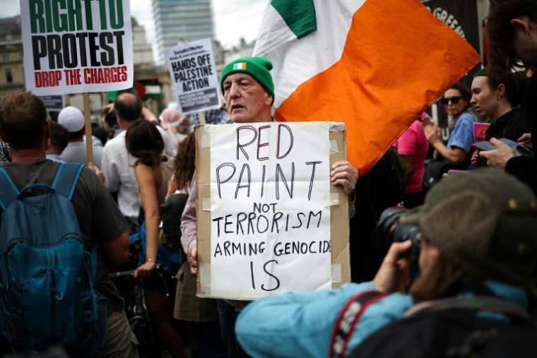 Un manifestant tient une pancarte "De la peinture rouge, pas du terrorisme, l'armement est un génocide" lors d'un rassemblement en soutien au groupe pro-palestinien Palestine Action, alors que le gouvernement britannique devrait annoncer l'interdiction du groupe, le 23 juin 2025 à Londres ( AFP / HENRY NICHOLLS )