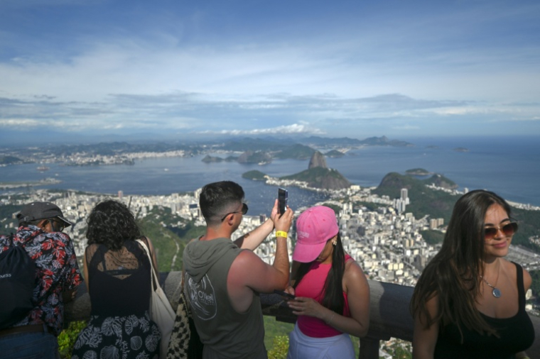 Un touriste prend des photos du Christ Rédempteur sur le mont Corcovado, dans le parc national de la forêt de Tijuca, à Rio de Janeiro, au Brésil, le 10 décembre 2025 ( AFP / Mauro PIMENTEL )