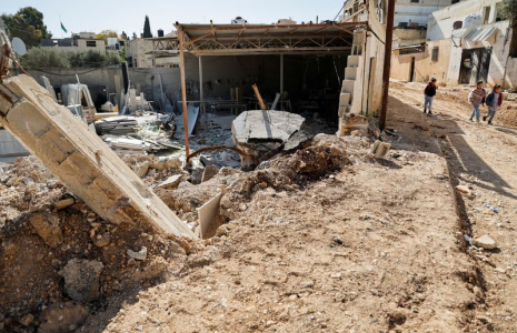 Des enfants palestiniens marchent près d'une route endommagée dans le camp de Jénine, en Cisjordanie occupée