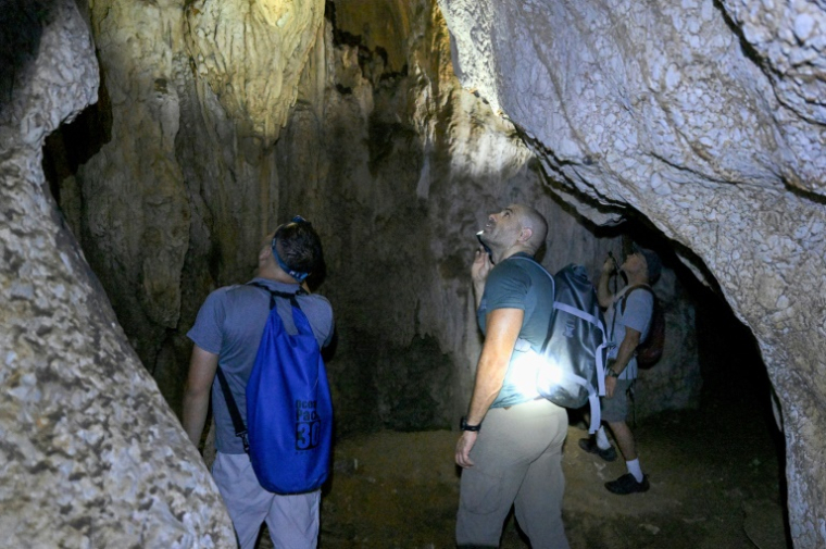 Des zoologues explorent une grotte à la recherche de nouvelles espèces le 22 juillet 2025 à Phnom Proek, dans la province de Battambang, au Cambodge ( AFP / TANG CHHIN Sothy )