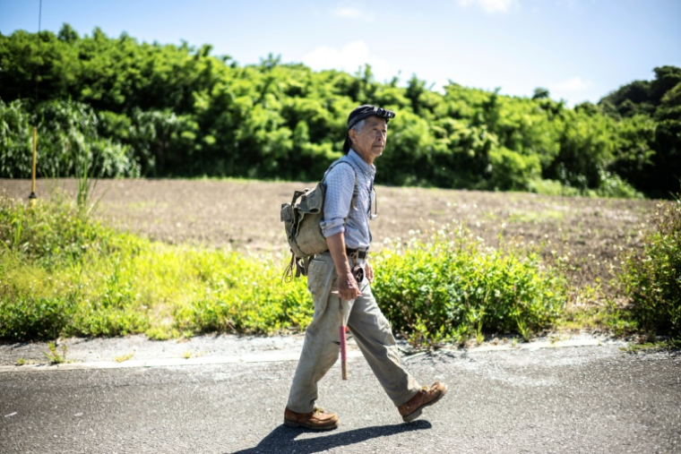 Takamatsu Gushiken se dirige vers la forêt d'Itoman pour rechercher des restes humains oubliés depuis la Seconde Guerre mondiale, dans la préfecture d'Okinawa, le 11 juin 2025 au Japon ( AFP / Philip FONG )