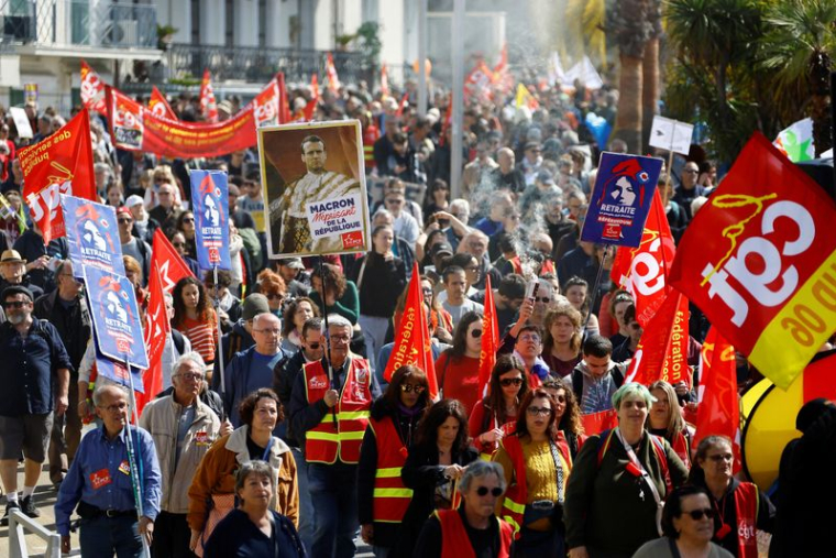 Des manifestants du syndicat CGT tiennent une pancarte représentant le président français Emmanuel Macron
